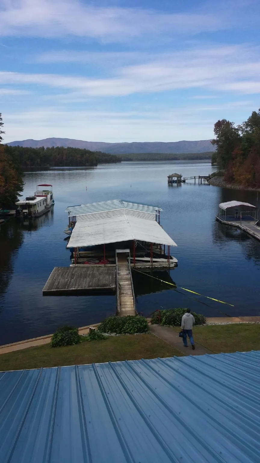 View across a lake from a newly installed blue metal roof in Geneseo